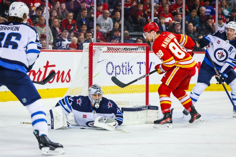 Feb 19, 2024; Calgary, Alberta, CAN; Winnipeg Jets goaltender Connor Hellebuyck (37) makes a save against Calgary Flames left wing Andrew Mangiapane (88) during the second period at Scotiabank Saddledome. Mandatory Credit: Sergei Belski-USA TODAY Sports