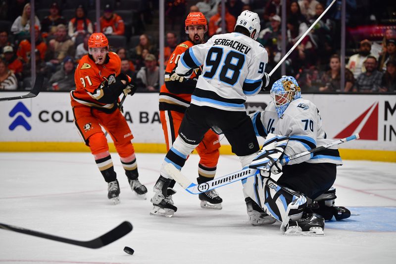 Nov 17, 2025; Anaheim, California, USA; Anaheim Ducks center Leo Carlsson (91) moves in for the rebound as Utah Mammoth defenseman Mikhail Sergachev (98) helps goaltender Karel Vejmelka (70) defend the goal against left wing Chris Kreider (20) during the second period at Honda Center. Mandatory Credit: Gary A. Vasquez-Imagn Images