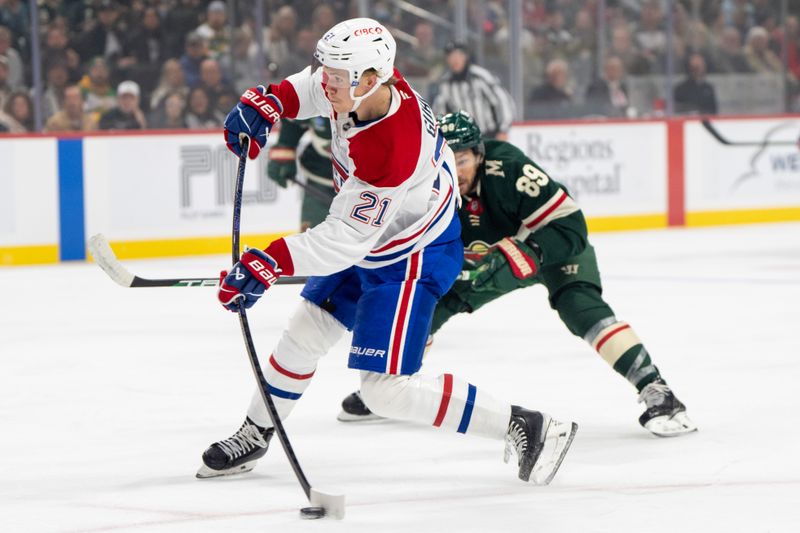 Nov 14, 2024; Saint Paul, Minnesota, USA; Montreal Canadiens defenseman Kaiden Guhle (21) shoots while Minnesota Wild center Frederick Gaudreau (89) is back on defense in the first period at Xcel Energy Center. Mandatory Credit: Matt Blewett-Imagn Images