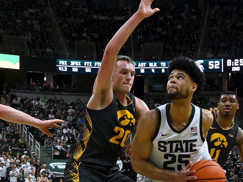 Feb 20, 2024; East Lansing, Michigan, USA;  Michigan State Spartans forward Malik Hall (25) eyes the basket while being guarded by Iowa Hawkeyes forward Payton Sandfort (20) during the second half at Jack Breslin Student Events Center. Mandatory Credit: Dale Young-USA TODAY Sports
