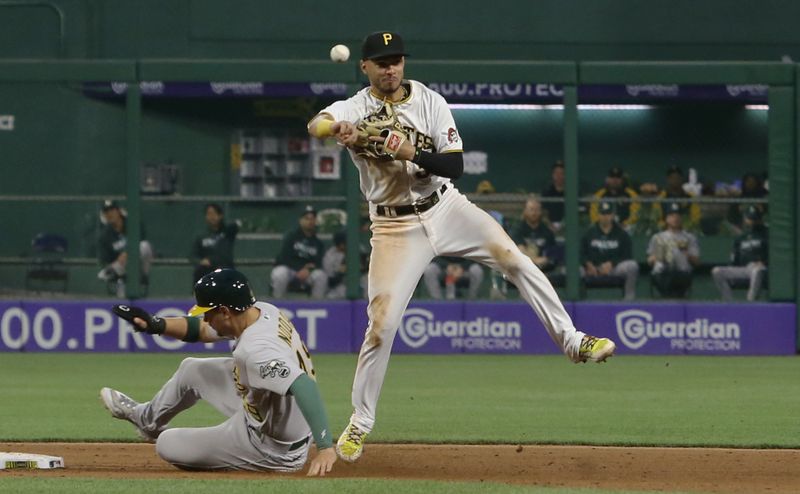 Jun 6, 2023; Pittsburgh, Pennsylvania, USA; Pittsburgh Pirates shortstop Tucupita Marcano (30) throws to first base to complete a double play over Oakland Athletics first baseman Ryan Noda (49) to end the sixth inning at PNC Park. Mandatory Credit: Charles LeClaire-USA TODAY Sports