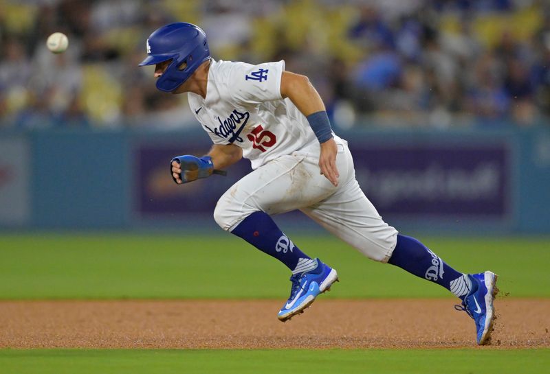 Aug 17, 2023; Los Angeles, California, USA;  Los Angeles Dodgers catcher Austin Barnes (15) beats the throw to Milwaukee Brewers shortstop Willy Adames (27) for a stolen base in the third inning at Dodger Stadium. Mandatory Credit: Jayne Kamin-Oncea-USA TODAY Sports