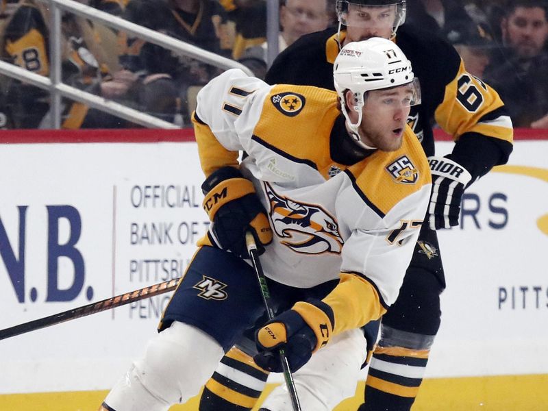 Apr 15, 2024; Pittsburgh, Pennsylvania, USA;  Nashville Predators center Mark Jankowski (17) moves the puck against Pittsburgh Penguins defenseman Erik Karlsson (65) during the first period at PPG Paints Arena. The Penguins won 4-2. Mandatory Credit: Charles LeClaire-USA TODAY Sports