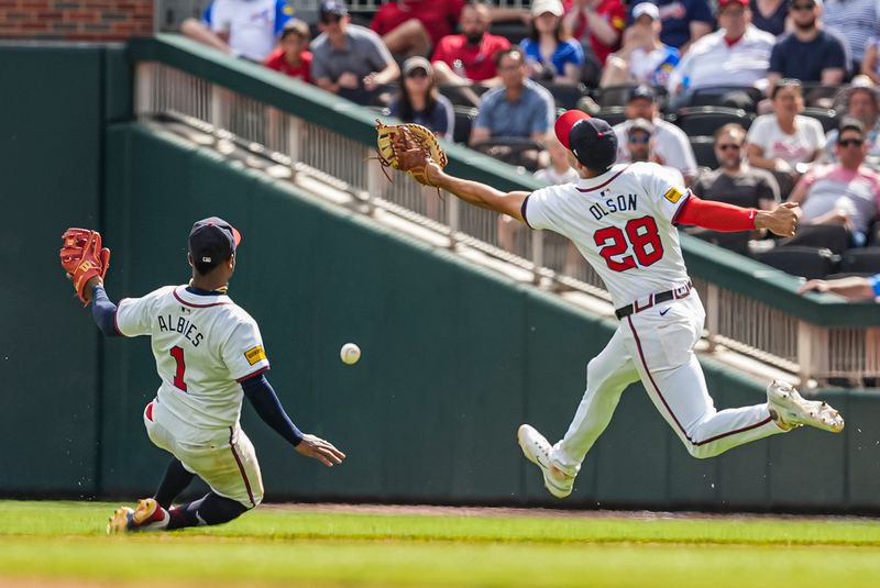 Apr 26, 2024; Cumberland, Georgia, USA; A ball hit by Cleveland Guardians third baseman Jose Ramirez (11) (not pictured) falls between Atlanta Braves second baseman Ozzie Albies (1) and first baseman Matt Olson (28) during the tenth inning at Truist Park. Mandatory Credit: Dale Zanine-USA TODAY Sports