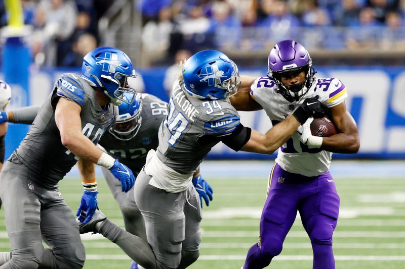 Minnesota Vikings running back Ty Chandler (32) is tackled by Detroit Lions linebacker Alex Anzalone (34) during the second half of an NFL football game, Sunday, Jan. 7, 2024, in Detroit. (AP Photo/Duane Burleson)