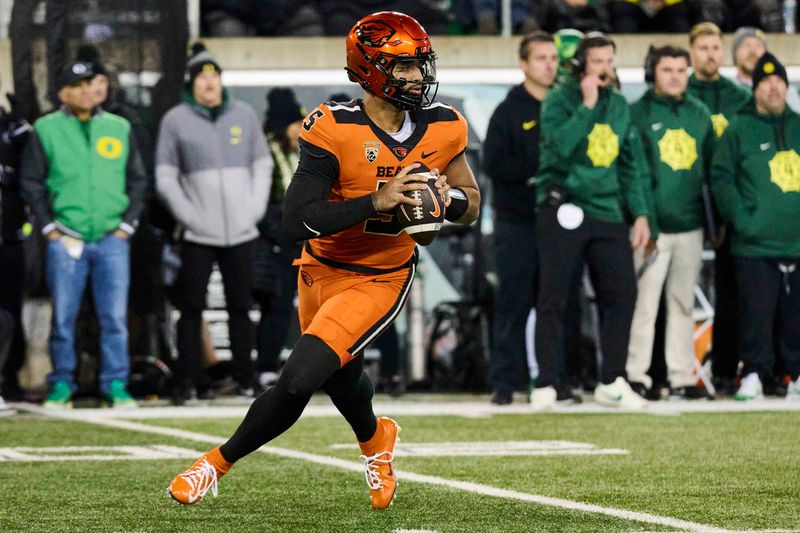 Nov 24, 2023; Eugene, Oregon, USA; Oregon State Beavers quarterback DJ Uiagalelei (5) rolls out to pass the ball during the first half against the Oregon Ducks at Autzen Stadium. Mandatory Credit: Troy Wayrynen-USA TODAY Sports