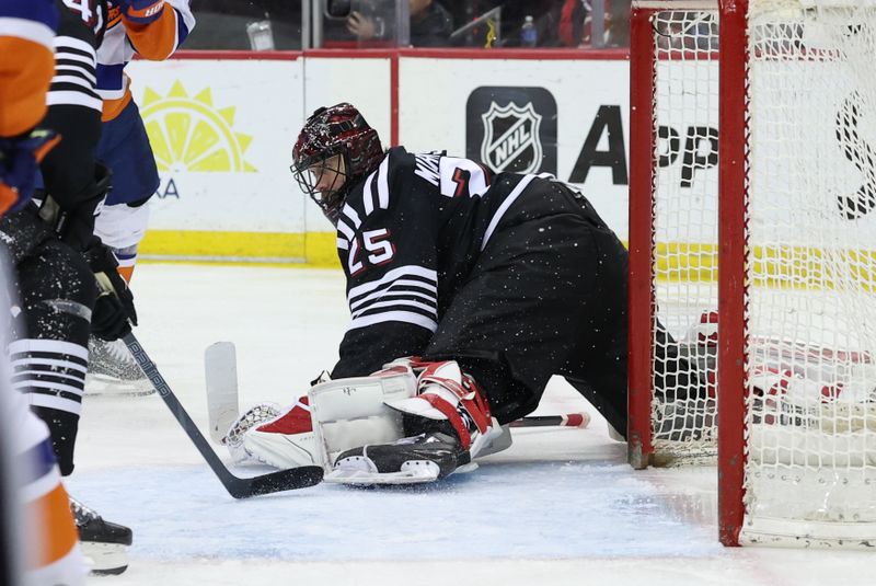 Apr 13, 2025; Newark, New Jersey, USA; New Jersey Devils goaltender Jacob Markstrom (25) makes a save against the New York Islanders during the third period at Prudential Center. Mandatory Credit: Ed Mulholland-Imagn Images
