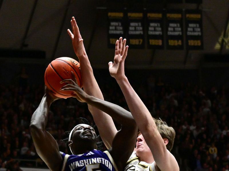 Jan 7, 2026; West Lafayette, Indiana, USA; Washington Huskies guard Zoom Diallo (5) shoots the ball against Purdue Boilermakers center Daniel Jacobsen (12) during the first half at Mackey Arena. Mandatory Credit: Marc Lebryk-Imagn Images