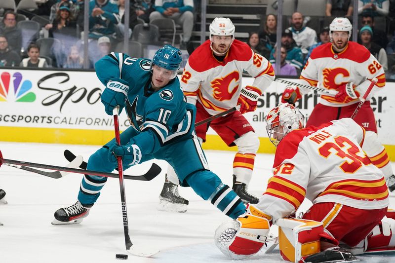 Apr 9, 2024; San Jose, California, USA; San Jose Sharks center Klim Kostin (10) attempts a shot against Calgary Flames goaltender Dustin Wolf (32) during the second period at SAP Center at San Jose. Mandatory Credit: David Gonzales-USA TODAY Sports