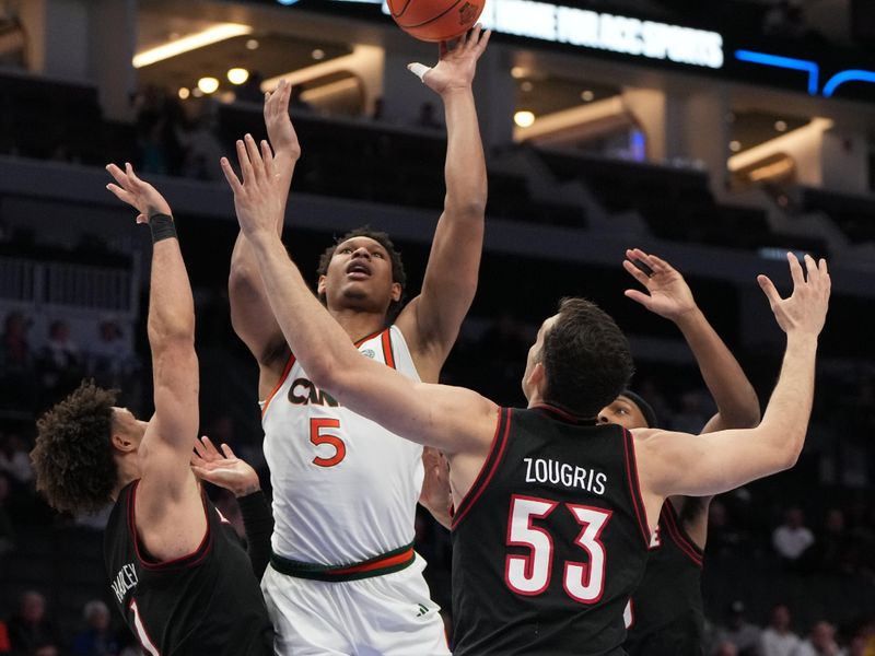 Mar 12, 2026; Charlotte, NC, USA; Miami (FL) Hurricanes forward Malik Reneau (5) shoots as Louisville Cardinals guard J'vonne Hadley (1) and forward Vangelis Zougris (53) defend in the second half at Spectrum Center. Mandatory Credit: Bob Donnan-Imagn Images