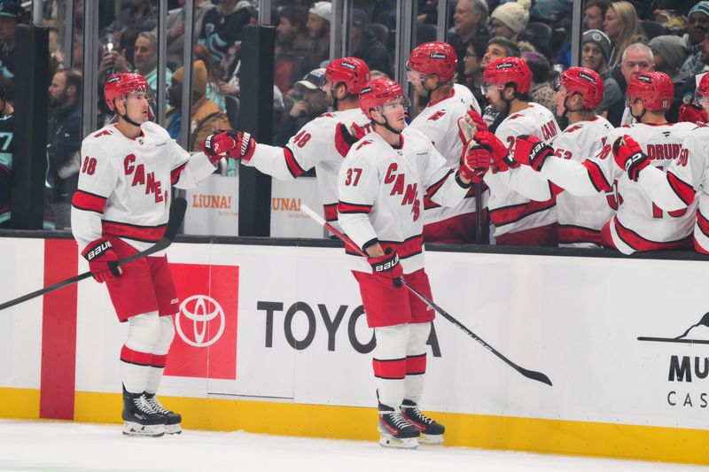 Oct 26, 2024; Seattle, Washington, USA; Carolina Hurricanes right wing Andrei Svechnikov (37) and center Martin Necas (88) celebrate with the bench after a goal scored by Svechnikov during the first period against the Seattle Kraken at Climate Pledge Arena. Mandatory Credit: Steven Bisig-Imagn Images