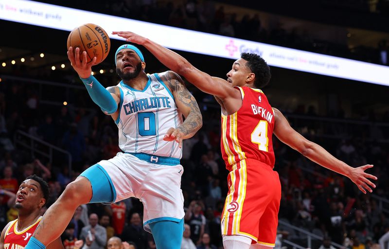 ATLANTA, GEORGIA - APRIL 10:  Miles Bridges #0 of the Charlotte Hornets scores the game-winning basket as he drives against Kobe Bufkin #4 of the Atlanta Hawks during the fourth quarter at State Farm Arena on April 10, 2024 in Atlanta, Georgia.  NOTE TO USER: User expressly acknowledges and agrees that, by downloading and/or using this photograph, user is consenting to the terms and conditions of the Getty Images License Agreement.  (Photo by Kevin C. Cox/Getty Images)