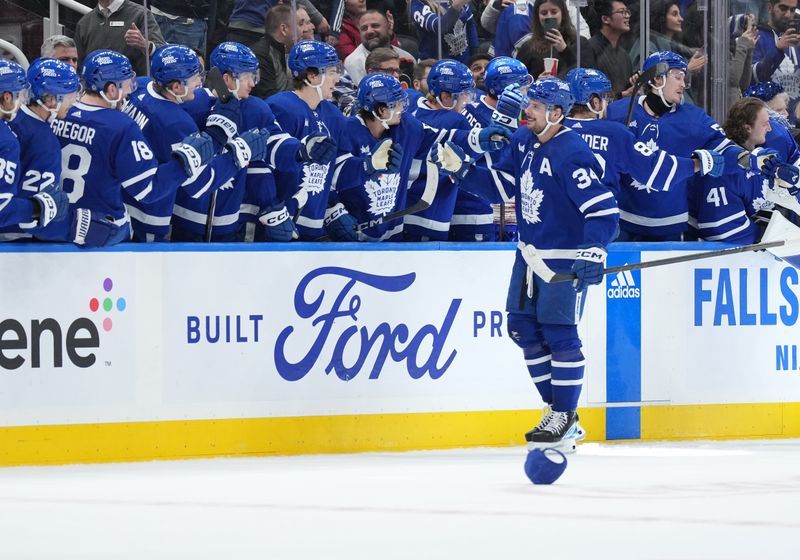 Feb 15, 2024; Toronto, Ontario, CAN; Toronto Maple Leafs center Auston Matthews (34) celebrates after scoring his third goal against the Philadelphia Flyers during the second period at Scotiabank Arena. Mandatory Credit: Nick Turchiaro-USA TODAY Sports