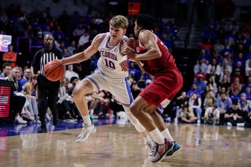 Feb 28, 2026; Gainesville, Florida, USA; Florida Gators forward Thomas Haugh (10) drives with the ball over Arkansas Razorbacks guard D.J. Wagner (21) during the second half at Exactech Arena at the Stephen C. O'Connell Center. Mandatory Credit: Travis Register-Imagn Images