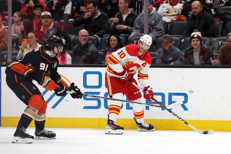 Dec 21, 2023; Anaheim, California, USA;  Calgary Flames center Jonathan Huberdeau (10) controls the puck against Anaheim Ducks center Leo Carlsson (91) during the first period at Honda Center. Mandatory Credit: Kiyoshi Mio-USA TODAY Sports