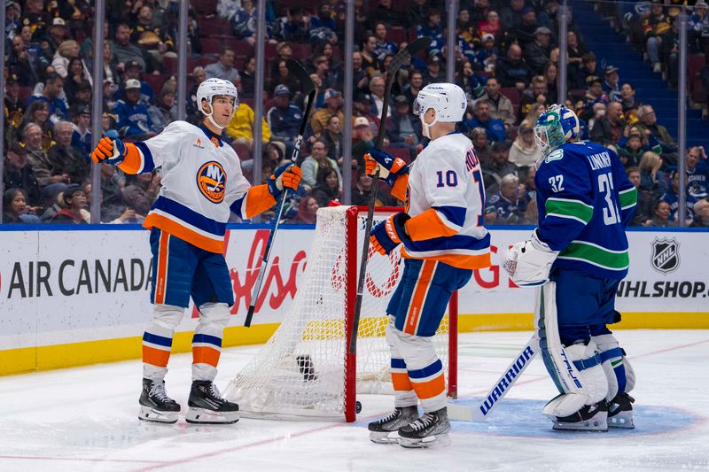 Nov 14, 2024; Vancouver, British Columbia, CAN; Vancouver Canucks goalie Kevin Lankinen (32) watches as New York Islanders forward Pierre Engvall (18) and forward Simon Holmstrom (10) celebrate Engvall’s goal against the Vancouver Canucks during the second period at Rogers Arena. Mandatory Credit: Bob Frid-Imagn Images