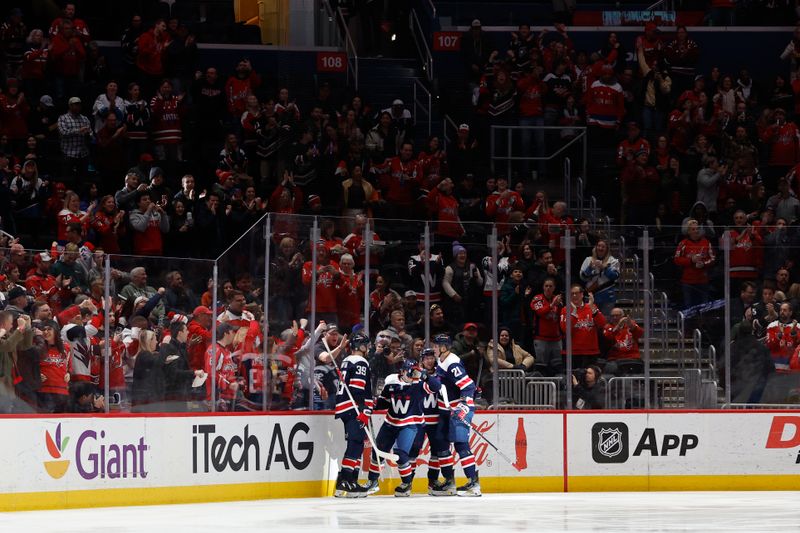 Feb 20, 2024; Washington, District of Columbia, USA; Washington Capitals center Connor McMichael (24) celebrates with teammates after scoring a goal against the New Jersey Devils in the first period at Capital One Arena. Mandatory Credit: Geoff Burke-USA TODAY Sports