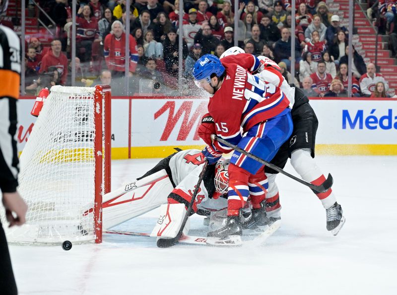 Jan 25, 2025; Montreal, Quebec, CAN; New Jersey Devils goalie Jake Allen (34) stops Montreal Canadiens forward Alex Newhook (15) during the overtime period at the Bell Centre. Mandatory Credit: Eric Bolte-Imagn Images