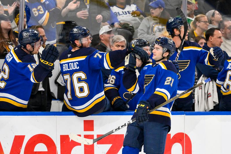 Apr 3, 2025; St. Louis, Missouri, USA;  St. Louis Blues right wing Jimmy Snuggerud (21) is congratulated by teammates after assisting on a goal by left wing Jake Neighbours (not pictured) for his first NHL point during the third period against the Pittsburgh Penguins at Enterprise Center. Mandatory Credit: Jeff Curry-Imagn Images