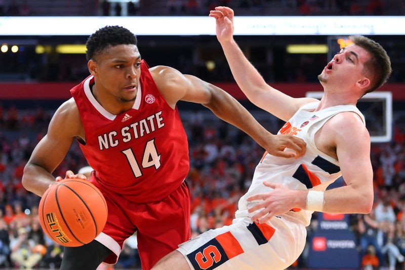 Feb 14, 2023; Syracuse, New York, USA; North Carolina State Wolfpack guard Casey Morsell (14) collides with Syracuse Orange guard Joseph Girard III (11) on a drive during the second half at the JMA Wireless Dome. An offensive foul was called on Morsell on the play. Mandatory Credit: Rich Barnes-USA TODAY Sports