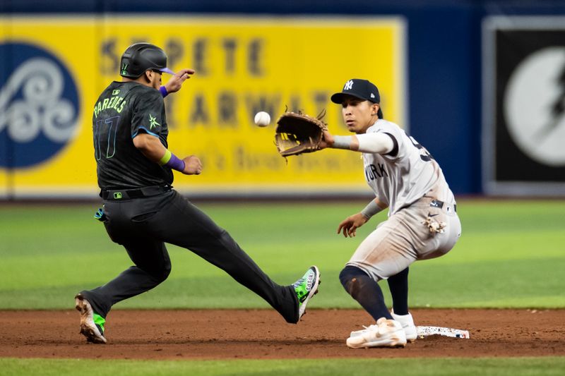 May 11, 2024; St. Petersburg, Florida, USA; Tampa Bay Rays third base Isaac Paredes (17) runs back to second base as New York Yankees third base Oswaldo Cabrera (95) catches the ball during the sixth inning at Tropicana Field. Mandatory Credit: Matt Pendleton-USA TODAY Sports