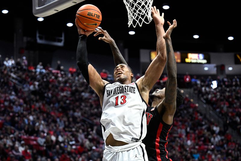 Jan 6, 2024; San Diego, California, USA; San Diego State Aztecs forward Jaedon LeDee (13) goes to the basket defended by UNLV Rebels forward Kalib Boone (10) during the first half at Viejas Arena. Mandatory Credit: Orlando Ramirez-USA TODAY Sports