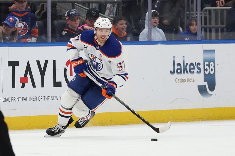 Mar 14, 2025; Elmont, New York, USA; Edmonton Oilers center Connor McDavid (97) controls the puck against the New York Islanders during overtime at UBS Arena. Mandatory Credit: Thomas Salus-Imagn Images