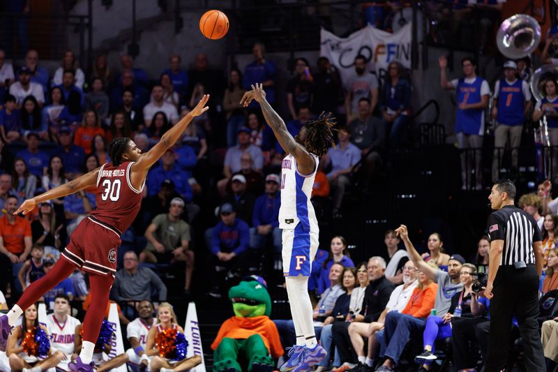 Feb 15, 2025; Gainesville, Florida, USA; Florida Gators guard Denzel Aberdeen (11) makes a three-point basket over South Carolina Gamecocks forward Collin Murray-Boyles (30) during the first half at Exactech Arena at the Stephen C. O'Connell Center. Mandatory Credit: Matt Pendleton-Imagn Images