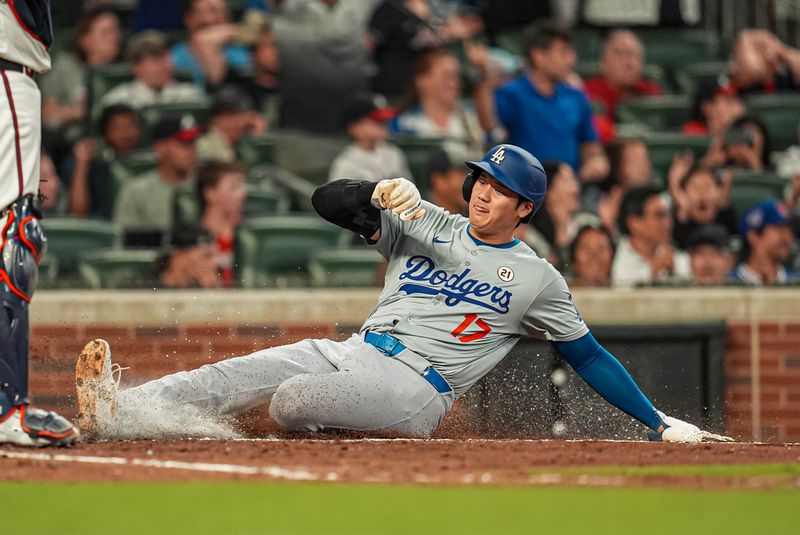 Sep 15, 2024; Cumberland, Georgia, USA; Los Angeles Dodgers designated hitter Shohei Ohtani (17) slides into home to score a run against the Atlanta Braves during the ninth inning at Truist Park. Mandatory Credit: Dale Zanine-Imagn Images