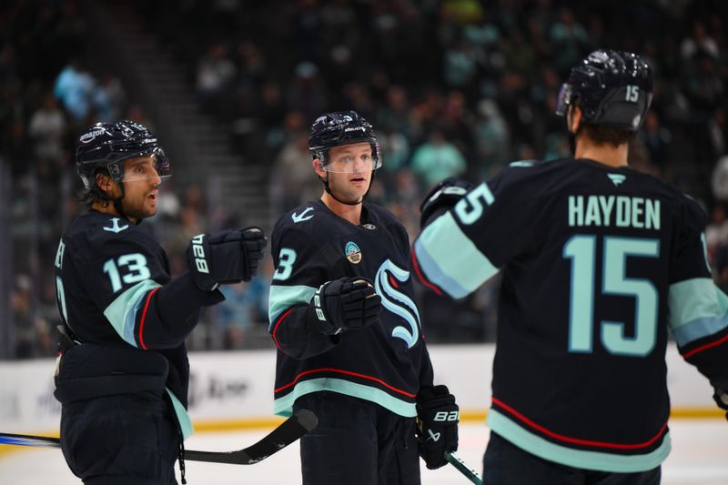 Oct 2, 2024; Seattle, Washington, USA; Seattle Kraken left wing Brandon Tanev (13) and defenseman Will Borgen (3) and center John Hayden (15) celebrate after Borgen scored a goal against the Edmonton Oilers during the third period at Climate Pledge Arena. Mandatory Credit: Steven Bisig-Imagn Images