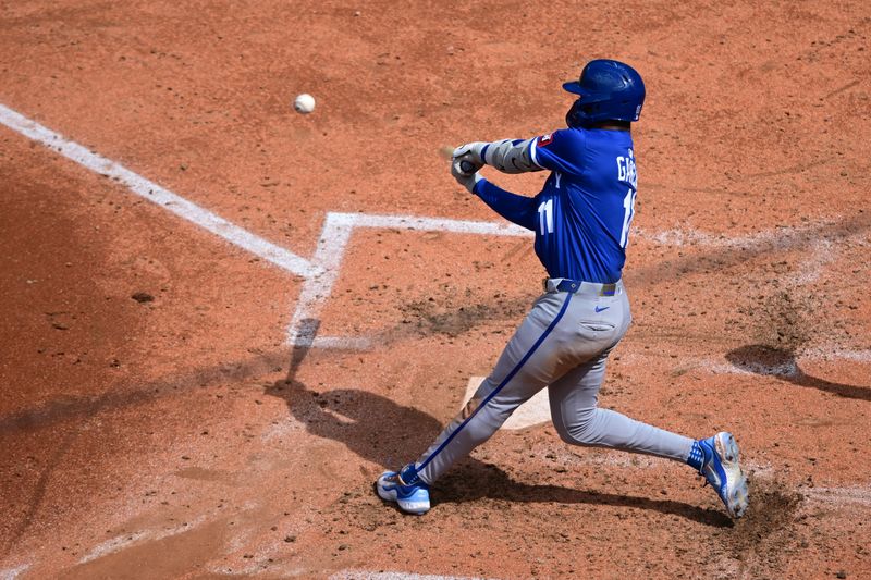 Apr 13, 2025; Cleveland, Ohio, USA; Kansas City Royals third baseman Maikel Garcia (11) hits an RBI double during the fifth inning against the Cleveland Guardians at Progressive Field. Mandatory Credit: David Dermer-Imagn Images