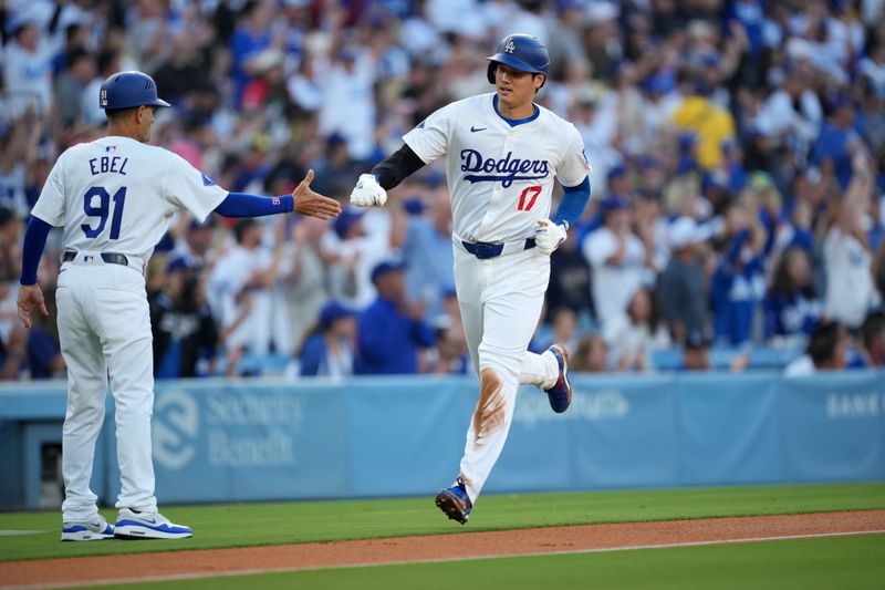 Jun 11, 2024; Los Angeles, California, USA; Los Angeles Dodgers designated hitter Shohei Ohtani (17) is congratulated by third base coach Dino Ebel (91) on the way to score in the first inning against the Texas Rangers at Dodger Stadium. Mandatory Credit: Kirby Lee-USA TODAY Sports