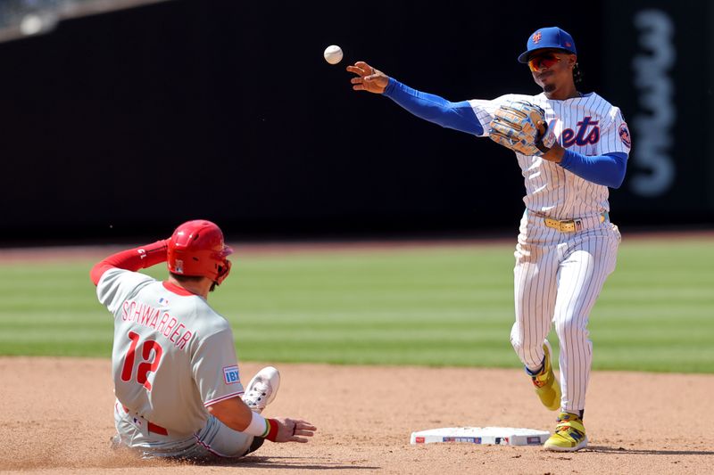 Apr 23, 2025; New York City, New York, USA; New York Mets shortstop Francisco Lindor (12) forces out Philadelphia Phillies designated hitter Kyle Schwarber (12) at second base and throws to first to complete a double play on a ball hit by Phillies catcher J.T. Realmuto (not pictured) during the fifth inning at Citi Field. Mandatory Credit: Brad Penner-Imagn Images