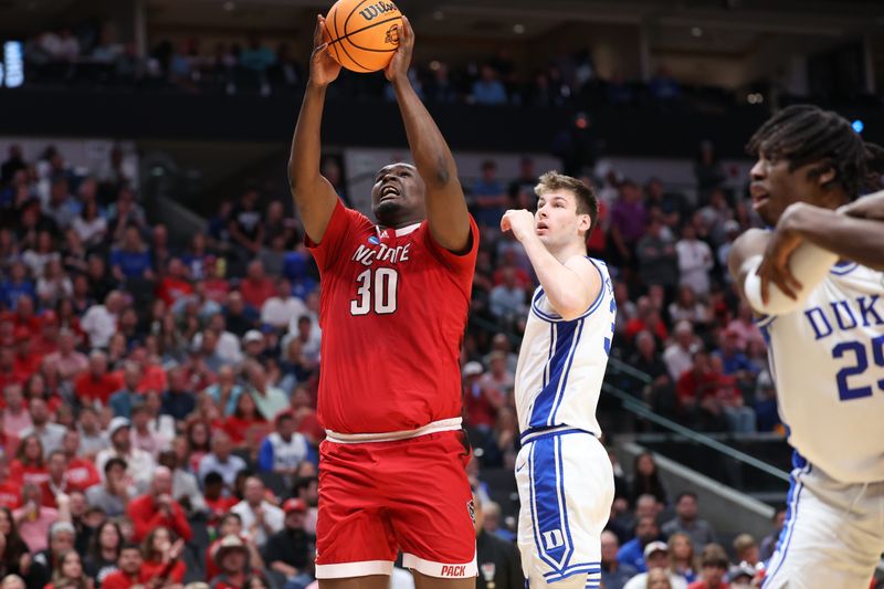 Mar 31, 2024; Dallas, TX, USA; North Carolina State Wolfpack forward DJ Burns Jr. (30) shoots against Duke Blue Devils center Kyle Filipowski (30) in the second half in the finals of the South Regional of the 2024 NCAA Tournament at American Airline Center. Mandatory Credit: Kevin Jairaj-USA TODAY Sports