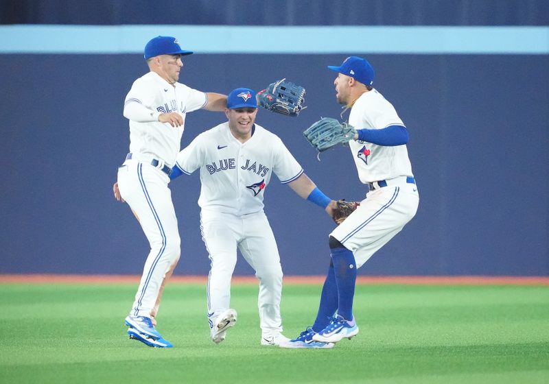 Jun 28, 2023; Toronto, Ontario, CAN; Toronto Blue Jays right fielder George Springer (4) and Toronto Blue Jays center fielder Daulton Varsho (25) and Toronto Blue Jays left fielder Whit Merrifield (15) celebrate the win against the San Francisco Giants at the end of the ninth inning at Rogers Centre. Mandatory Credit: Nick Turchiaro-USA TODAY Sports