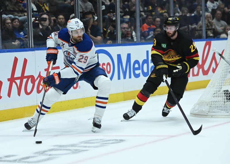 Oct 26, 2025; Vancouver, British Columbia, CAN;Edmonton Oilers center Leon Draisaitl (29) skates with the puck against Vancouver Canucks defenseman Marcus Pettersson (29) during the first period   at Rogers Arena. Mandatory Credit: Simon Fearn-Imagn Images