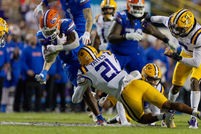 Nov 11, 2023; Baton Rouge, Louisiana, USA;  Florida Gators running back Trevor Etienne (7) rushes against LSU Tigers safety Ryan Yaites (21) during the second half at Tiger Stadium. Mandatory Credit: Stephen Lew-USA TODAY Sports