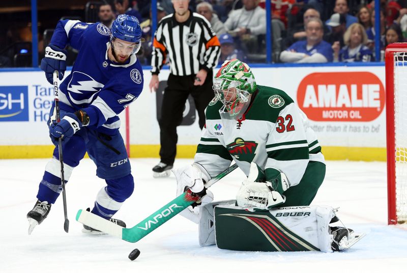 Jan 18, 2024; Tampa, Florida, USA; Minnesota Wild goaltender Filip Gustavsson (32) makes a save as Tampa Bay Lightning center Anthony Cirelli (71) skates during the first period at Amalie Arena. Mandatory Credit: Kim Klement Neitzel-USA TODAY Sports