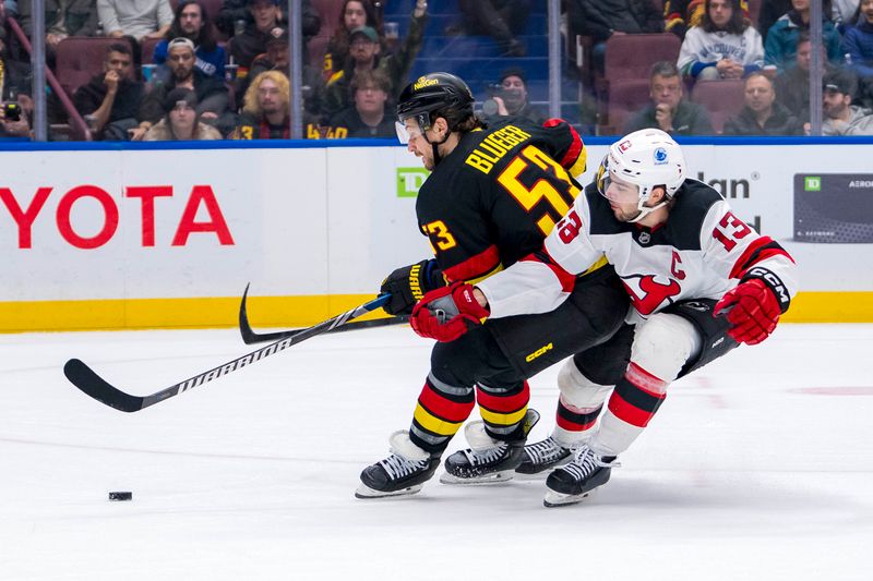 Oct 30, 2024; Vancouver, British Columbia, CAN; New Jersey Devils forward Nico Hischier (13) stick checks Vancouver Canucks forward Teddy Blueger (53) during the second period at Rogers Arena. Mandatory Credit: Bob Frid-Imagn Images