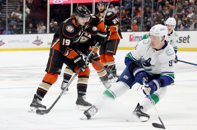 Mar 3, 2024; Anaheim, California, USA; Anaheim Ducks right wing Troy Terry (19) avoids Vancouver Canucks defenseman Nikita Zadorov (91) during the second period at Honda Center. Mandatory Credit: Jason Parkhurst-USA TODAY Sports