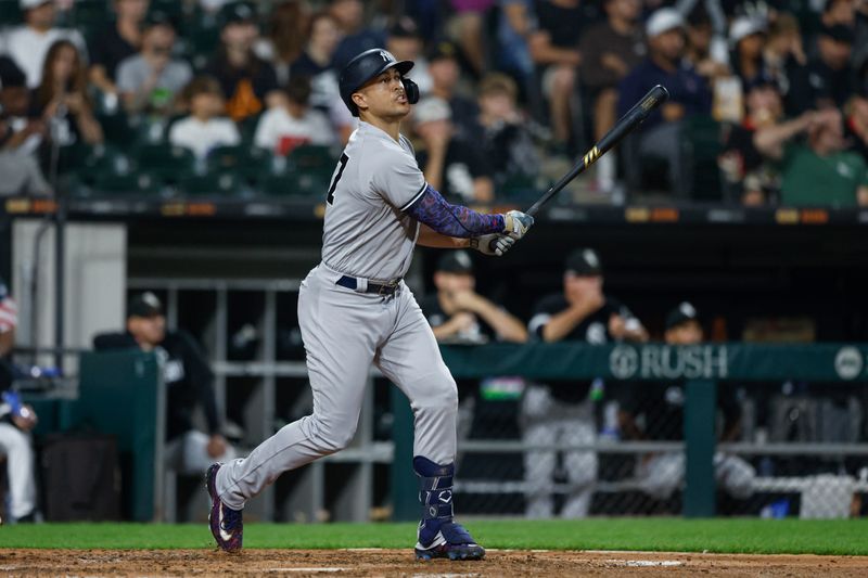 Aug 9, 2023; Chicago, Illinois, USA; New York Yankees designated hitter Giancarlo Stanton (27) hits a solo home run against the Chicago White Sox during the seventh inning at Guaranteed Rate Field. Mandatory Credit: Kamil Krzaczynski-USA TODAY Sports