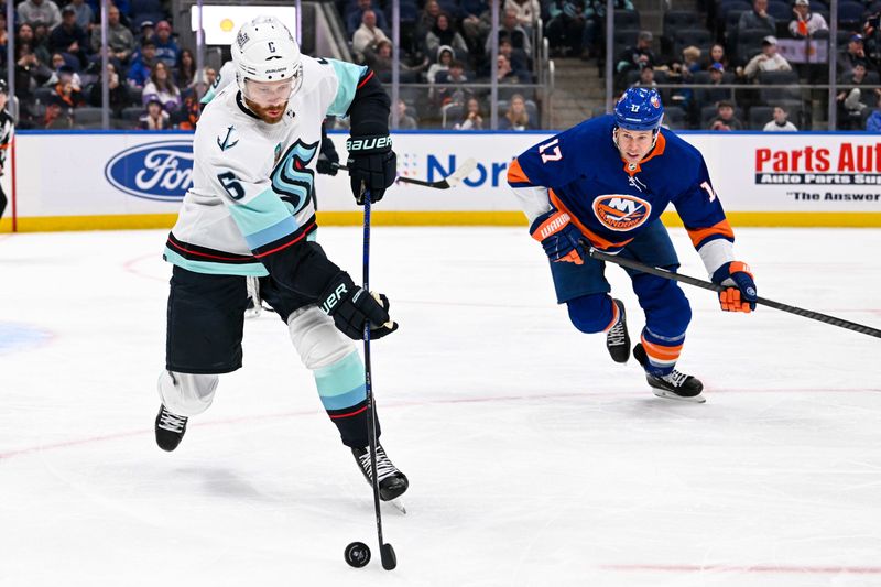 Feb 13, 2024; Elmont, New York, USA; Seattle Kraken defenseman Adam Larsson (6) plays the puck defended by New York Islanders left wing Matt Martin (17) during the second period at UBS Arena. Mandatory Credit: Dennis Schneidler-USA TODAY Sports