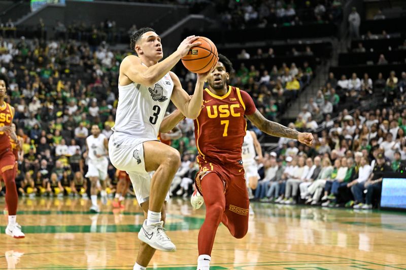 Mar 1, 2025; Eugene, Oregon, USA; Oregon Ducks guard Jackson Shelstad (3) drives to the basket past USC Trojans guard Chibuzo Agbo (7) during the first half at Matthew Knight Arena. Mandatory Credit: Craig Strobeck-Imagn Images