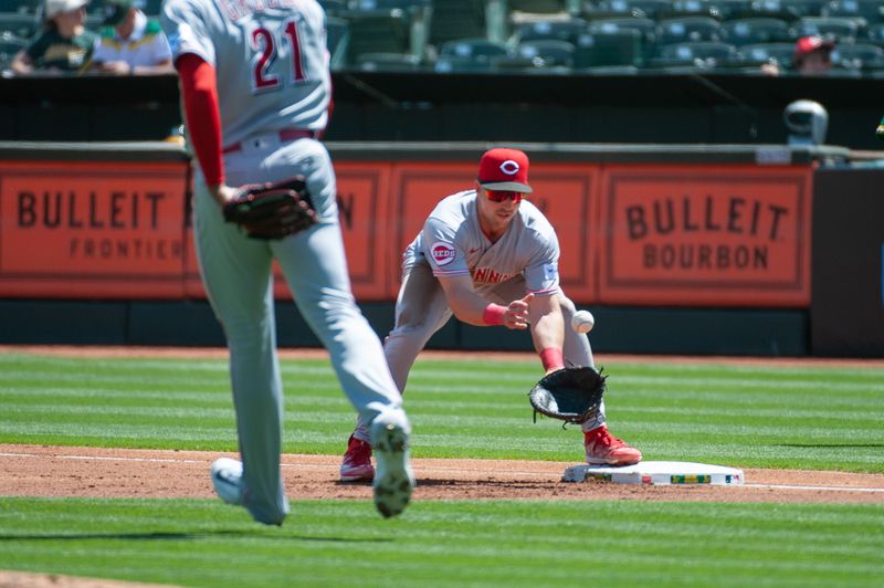 Apr 29, 2023; Oakland, California, USA; Cincinnati Reds starting pitcher Hunter Greene (21) tosses the ball to first baseman Spencer Steer (7) during the first inning against the Oakland Athletics at RingCentral Coliseum. Mandatory Credit: Ed Szczepanski-USA TODAY Sports