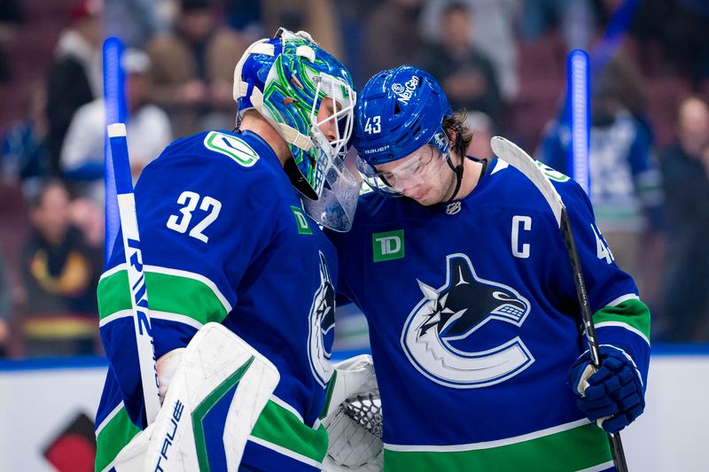 Nov 12, 2024; Vancouver, British Columbia, CAN; Vancouver Canucks goalie Kevin Lankinen (32) and defenseman Quinn Hughes (43) celebrate a victory against the Calgary Flames at Rogers Arena. Mandatory Credit: Bob Frid-Imagn Images