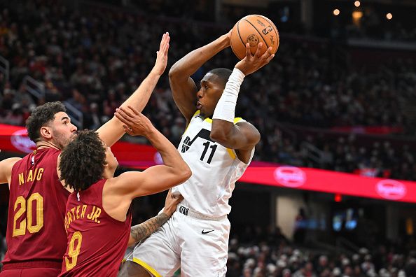 CLEVELAND, OHIO - DECEMBER 20: Georges Niang #20 and Craig Porter #9 of the Cleveland Cavaliers guard Kris Dunn #11 of the Utah Jazz during the third quarter at Rocket Mortgage Fieldhouse on December 20, 2023 in Cleveland, Ohio. The Cavaliers defeated the Jazz 124-116. NOTE TO USER: User expressly acknowledges and agrees that, by downloading and or using this photograph, User is consenting to the terms and conditions of the Getty Images License Agreement. (Photo by Jason Miller/Getty Images)