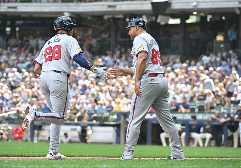 Jul 31, 2024; Milwaukee, Wisconsin, USA; Atlanta Braves first baseman Matt Olson (28) celebrates with third base coach Matt Tuiasosopo (89) after hitting a home run against the Milwaukee Brewers in the seventh inning at American Family Field. Mandatory Credit: Michael McLoone-USA TODAY Sports