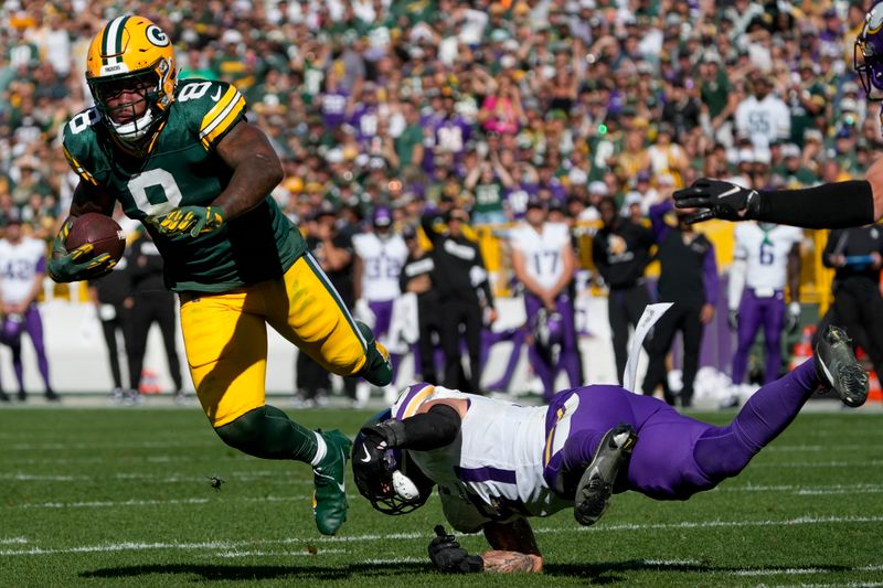 Green Bay Packers running back Josh Jacobs (8) is tackled by Minnesota Vikings linebacker Blake Cashman, right, during the second half of an NFL football game Sunday, Sept. 29, 2024, in Green Bay, Wis. (AP Photo/Morry Gash)