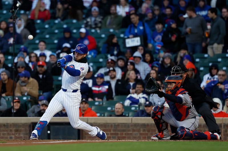 Apr 24, 2024; Chicago, Illinois, USA; Chicago Cubs first baseman Michael Busch (29) hits an RBI-sacrifice fly against the Houston Astros during the first inning at Wrigley Field. Mandatory Credit: Kamil Krzaczynski-USA TODAY Sports