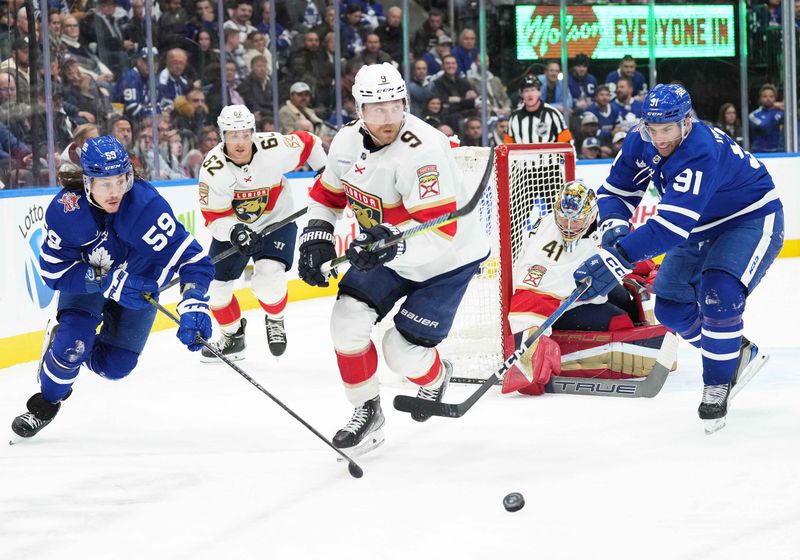 Nov 28, 2023; Toronto, Ontario, CAN; Florida Panthers center Sam Bennett (9) battles for the puck between Toronto Maple Leafs left wing Tyler Bertuzzi (59) and Toronto Maple Leafs center John Tavares (91) during the third period at Scotiabank Arena. Mandatory Credit: Nick Turchiaro-USA TODAY Sports